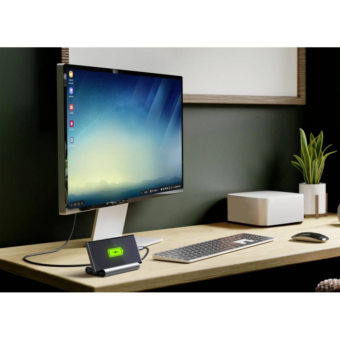 Een desktopcomputer met toetsenbord en muis toont een geüpload batterij-pictogram op het smartphonedisplay in een dock op het bureau.