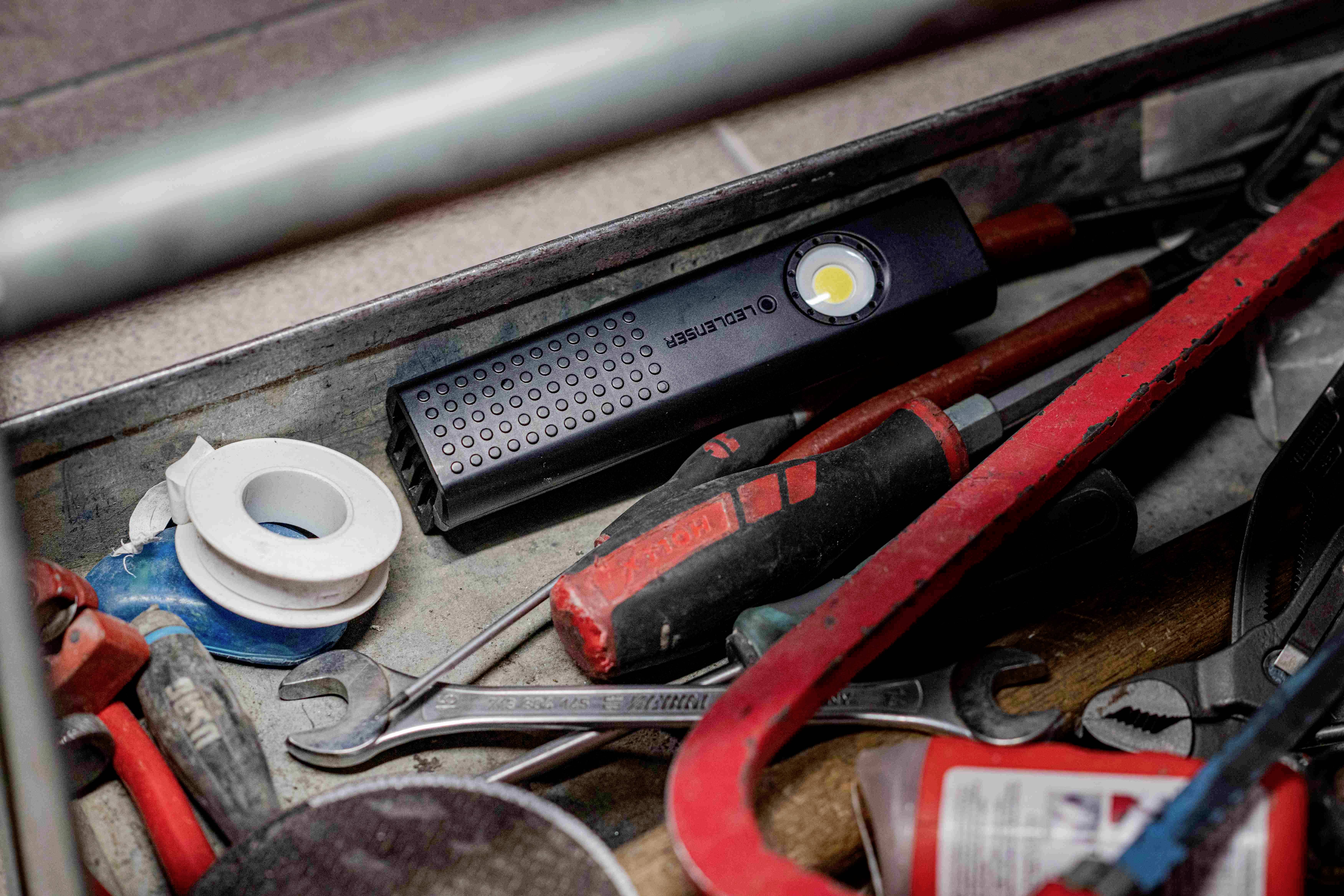 Gereedschapskoffer met zaklamp, moersleutel, isolatietape en schroevendraaier.