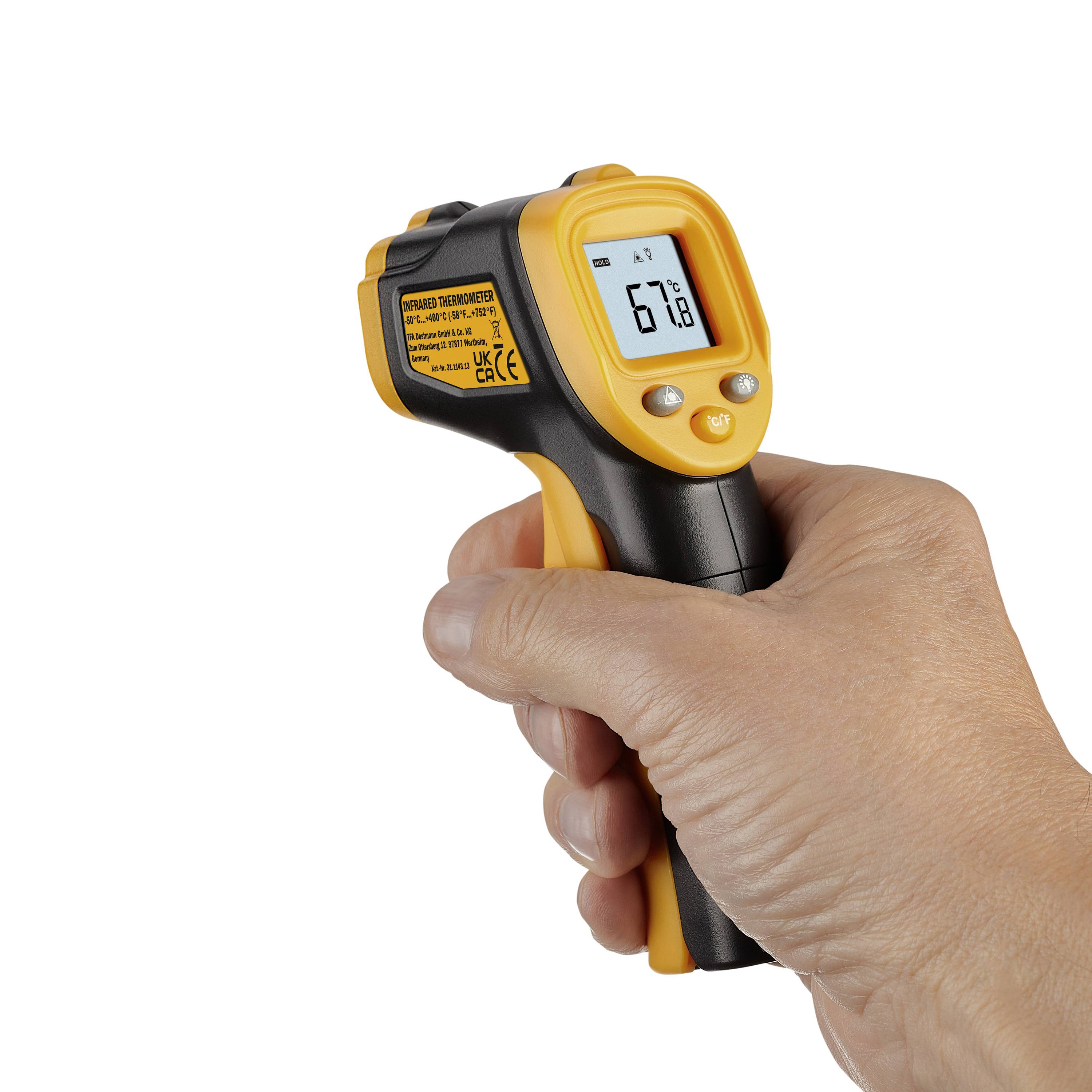 Een hand houdt een gele infrarood-thermometer vast die een temperatuur van 67,8 graden weergeeft.