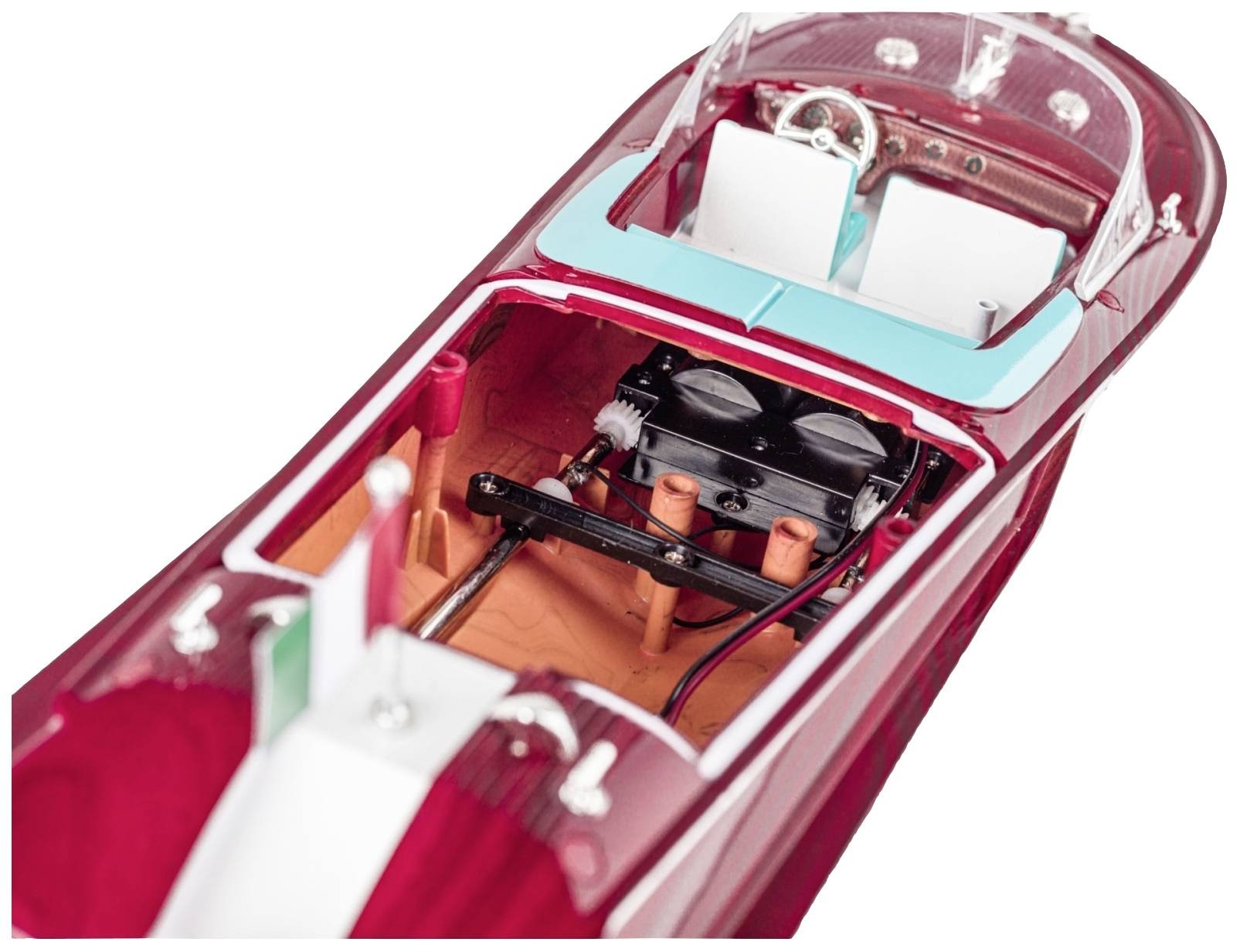 Een modelboot toont het interieur met motor, zitplaatsen en stuurwiel. De boot is rood met blauwe en witte details.