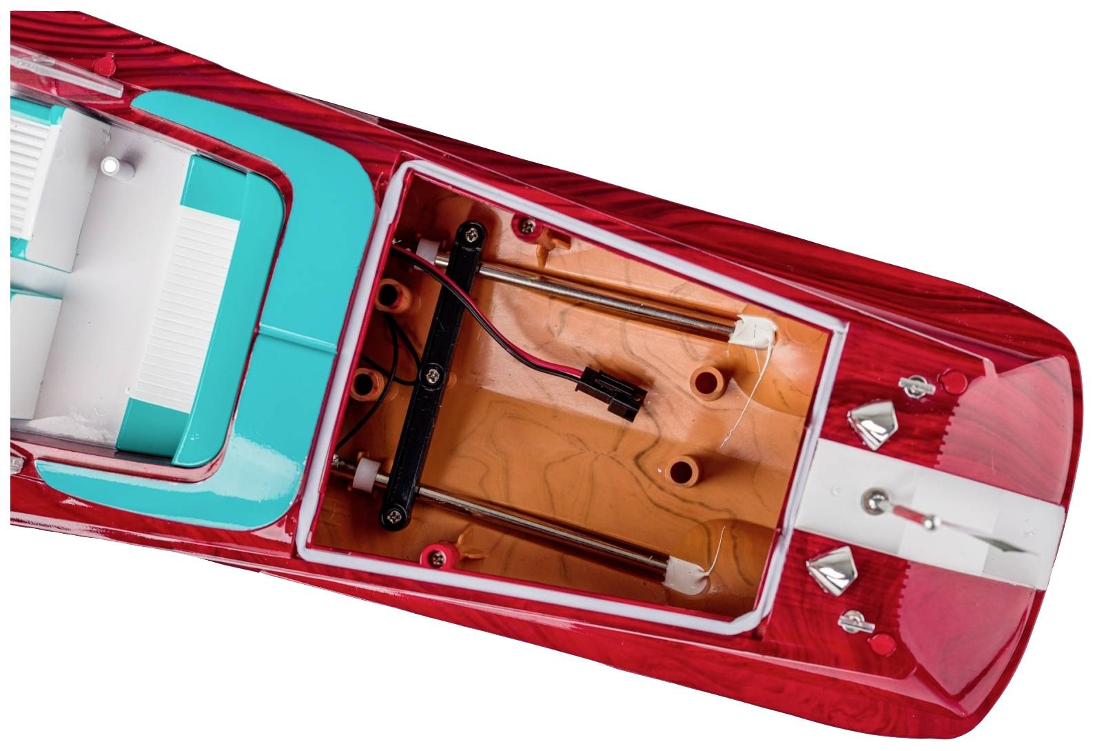 Bovenaanzicht van een rood-wit modelboot. Het interieur is zichtbaar en toont bekabeling en technische componenten.