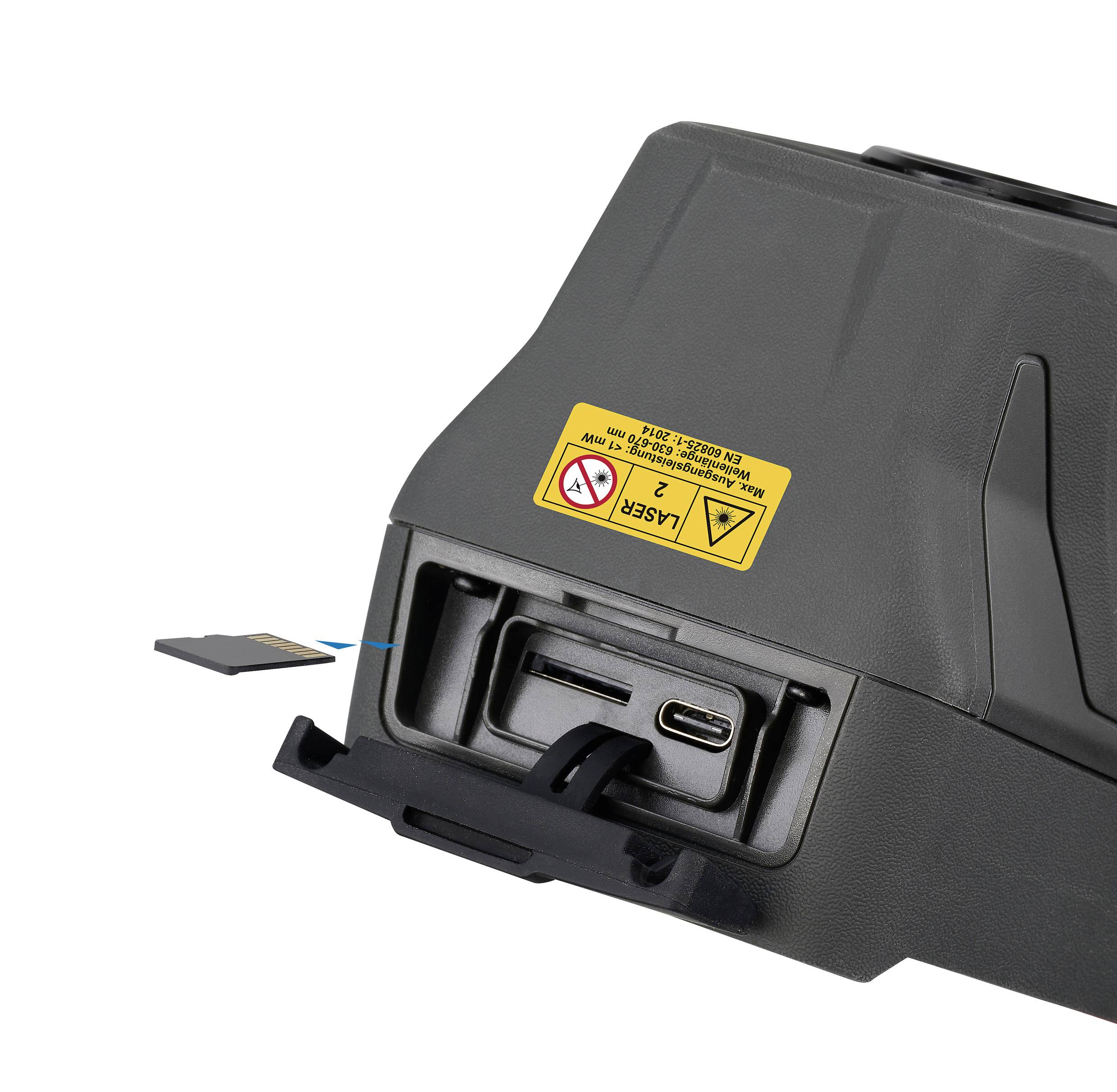 Een zwart apparaat met een geel waarschuwingsetiket. Het heeft aansluitingen voor USB-C en een geheugenkaart, gedeeltelijk uit een lade gehaald.