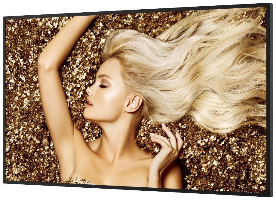 Vrouw met lang blond haar ligt op gouden lovertjes en kijkt omhoog, elegant en glamoureus weergegeven.
