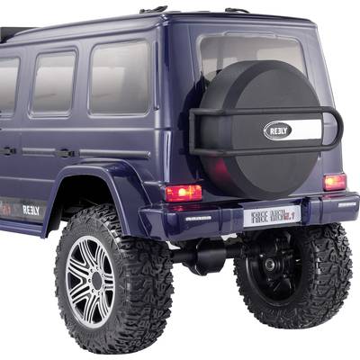 Een blauwe speelgoed terreinwagen met grote offroad-banden en een reservewiel achterop. Voertuig staat op een gladde ondergrond.