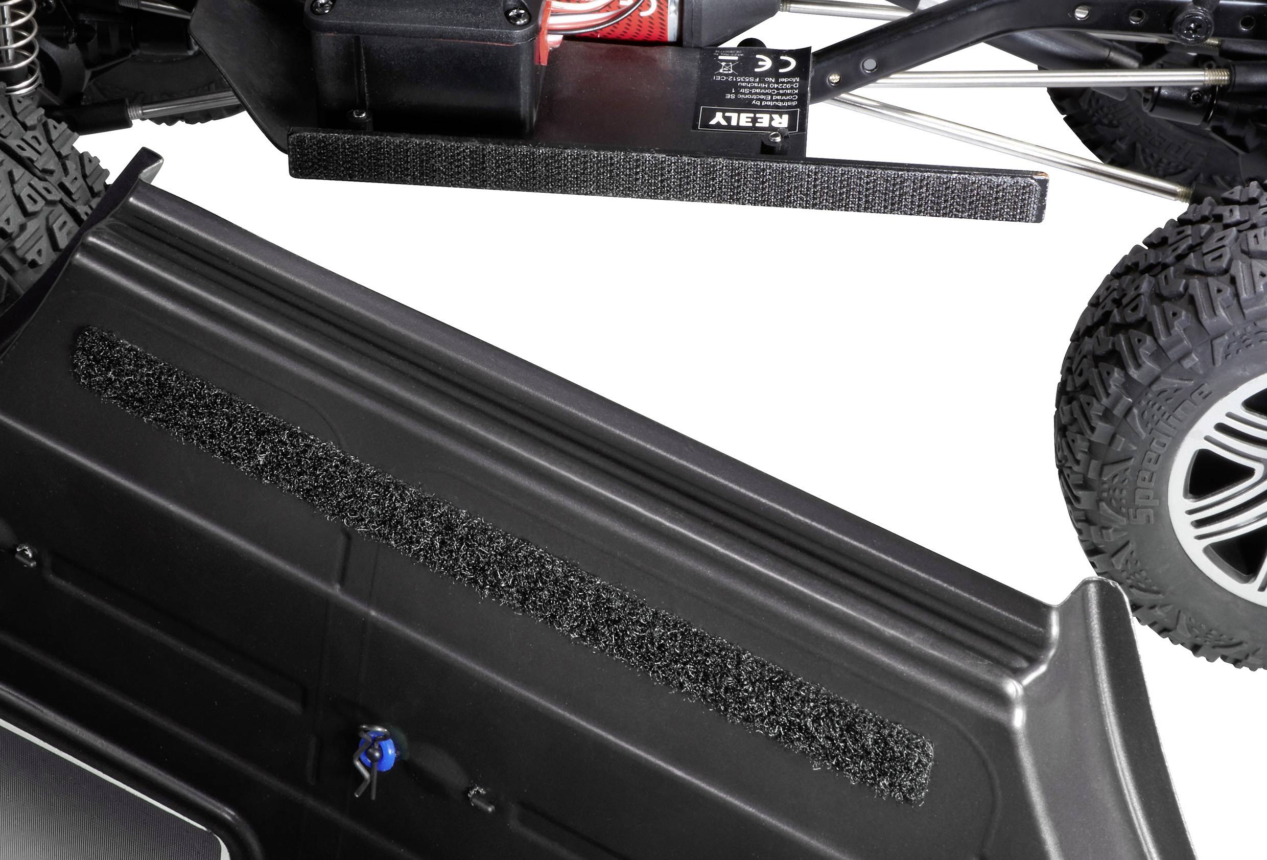 Afstandsbediend voertuig, met focus op het zwarte kunststof chassis met textuurdetail en wielgedeelte. Bovenste deel van de voertuigmechanica zichtbaar.