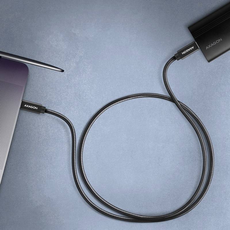 Een laptop is met een USB-kabel aangesloten op een extern apparaat. De kabel verbindt de laptop met een zwarte externe harde schijf.
