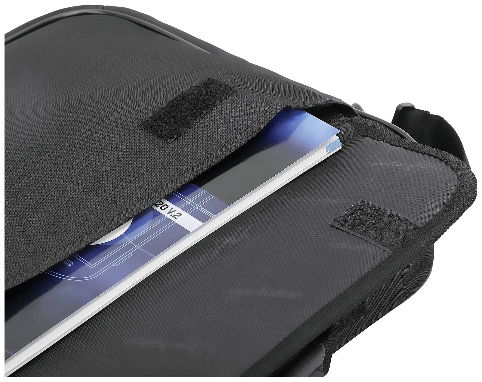 Een zwarte schoudertas met een tijdschrift en een blauw boek zichtbaar in de geopende tas.