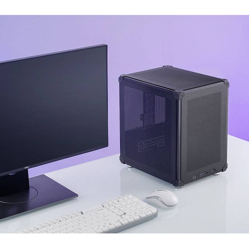 Een monitor, een toetsenbord en een muis staan op een tafel naast een kleine, vierkante computerbehuizing.
