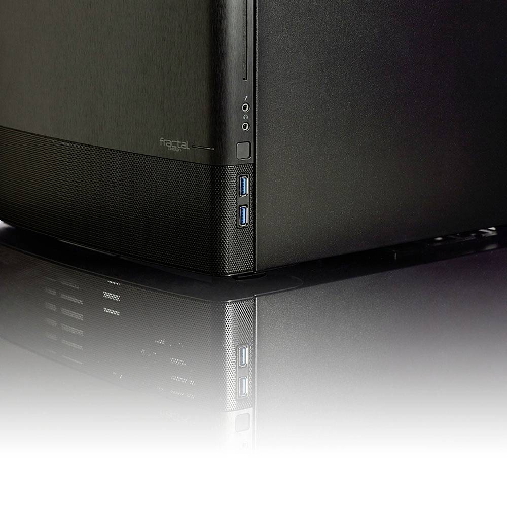 Een zwarte computerbehuizing met meerdere USB-poorten aan de zijkant staat op een reflecterende oppervlakte.