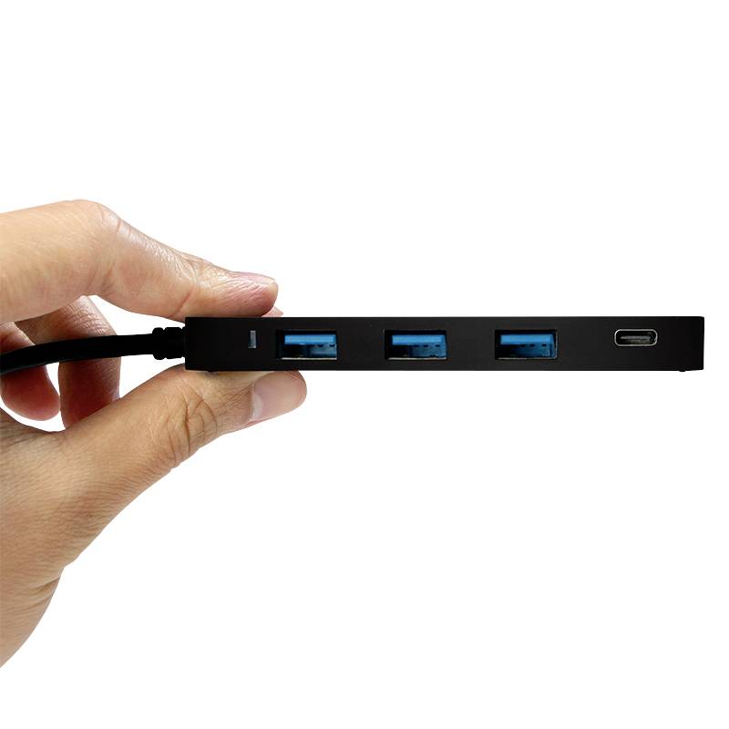 Een hand houdt een slanke zwarte USB-hub met vier poorten: drie USB-A en een USB-C.