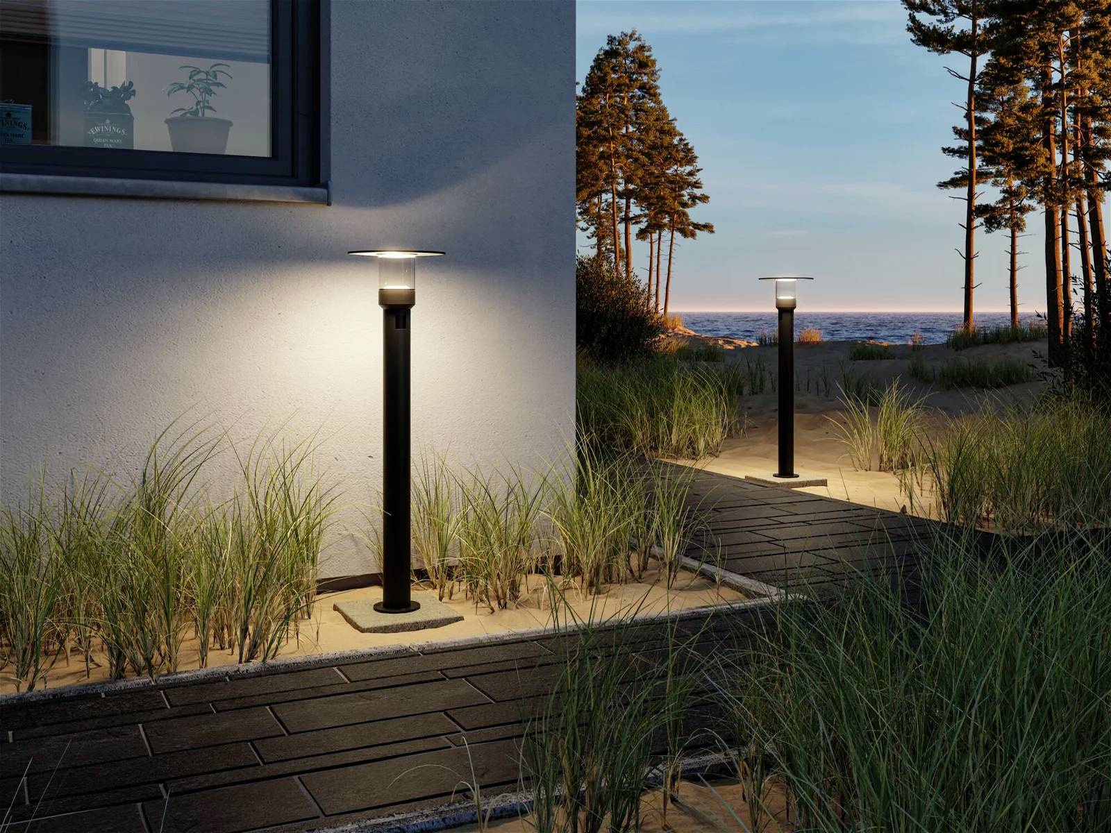 Twee tuinlampen langs een bestrate weg, omringd door grassen, verlichten een tuin bij zonsondergang.