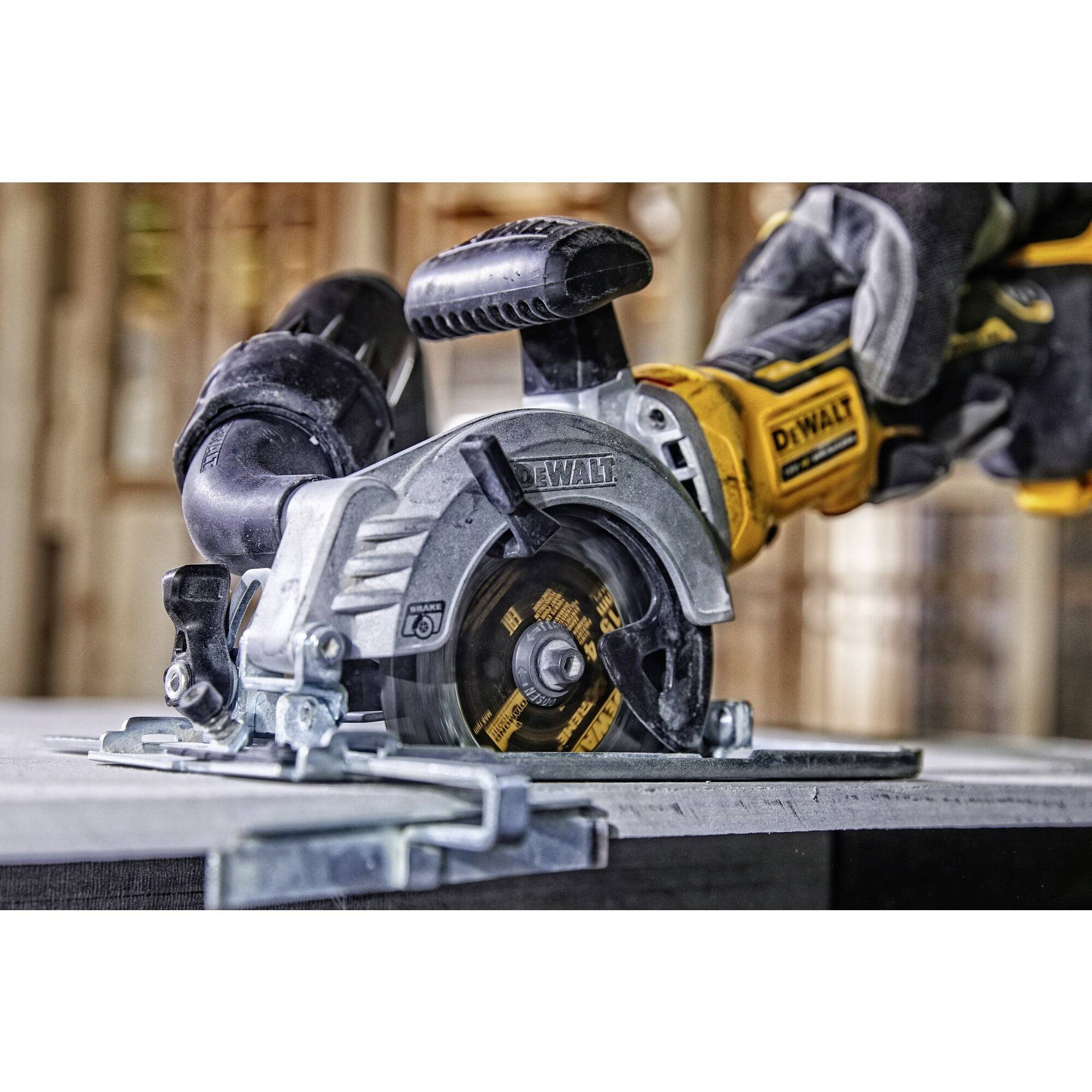 Een persoon zaagt een metalen buis met een gele elektrische zaag. De zaag heeft een zwart behuizing. De achtergrond toont een onscherpe houtstructuur.