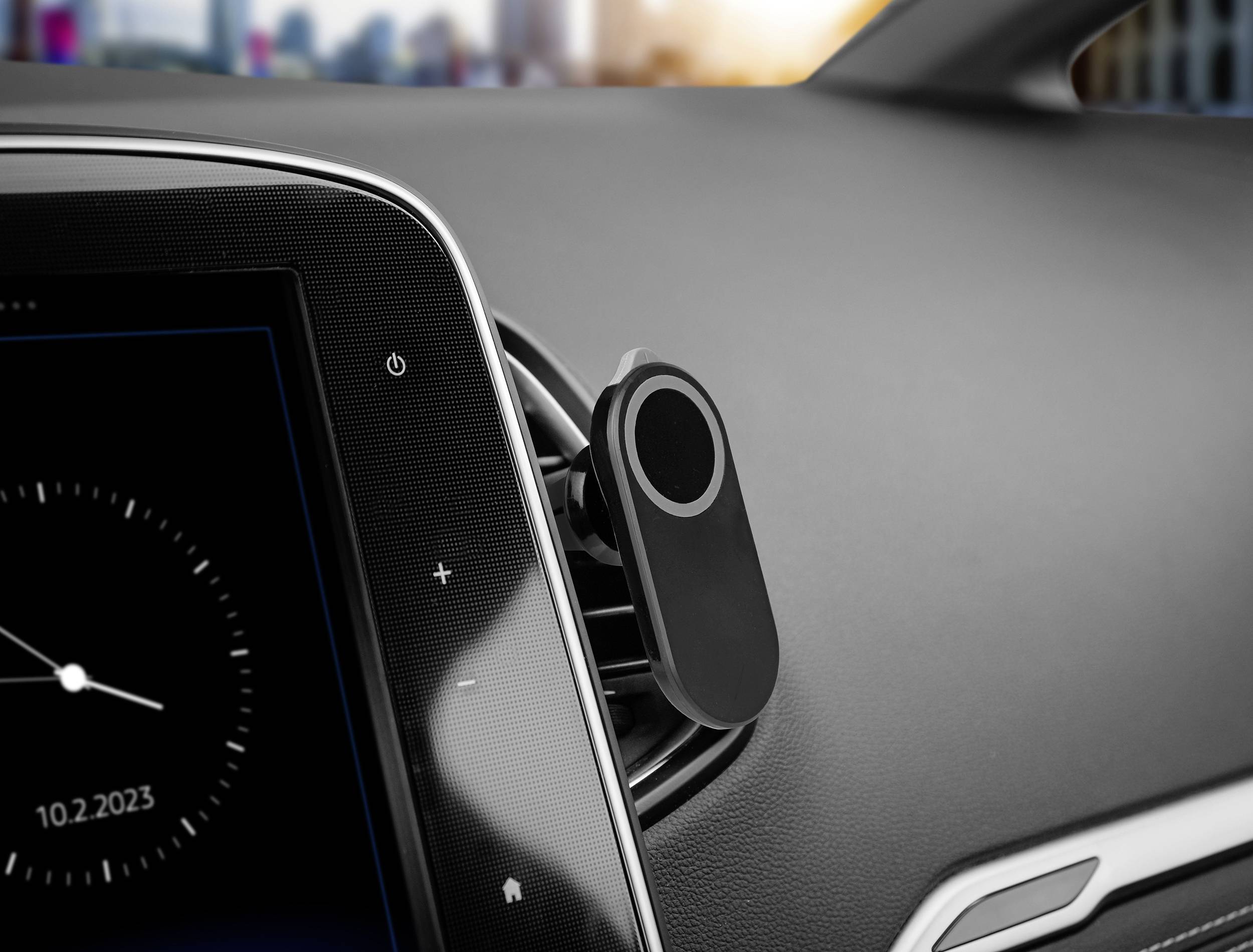 Afbeelding van een auto-dashboard met een digitaal display. Op het scherm wordt de tijd weergegeven, met op de achtergrond een wazig stadsgezicht.