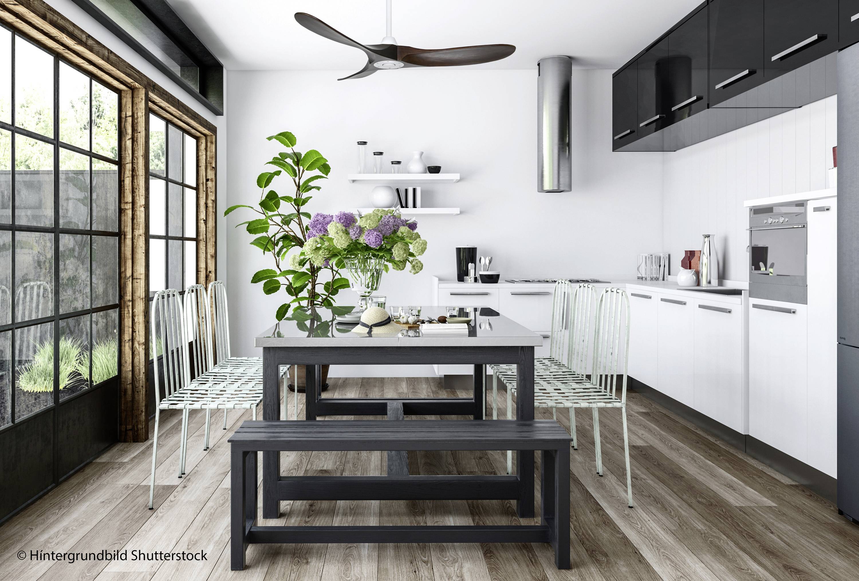 Moderne keuken met eettafel, vier stoelen en een bank. Decoratieve planten op tafel, grote ramen aan de linkerkant, witte en zwarte meubels.