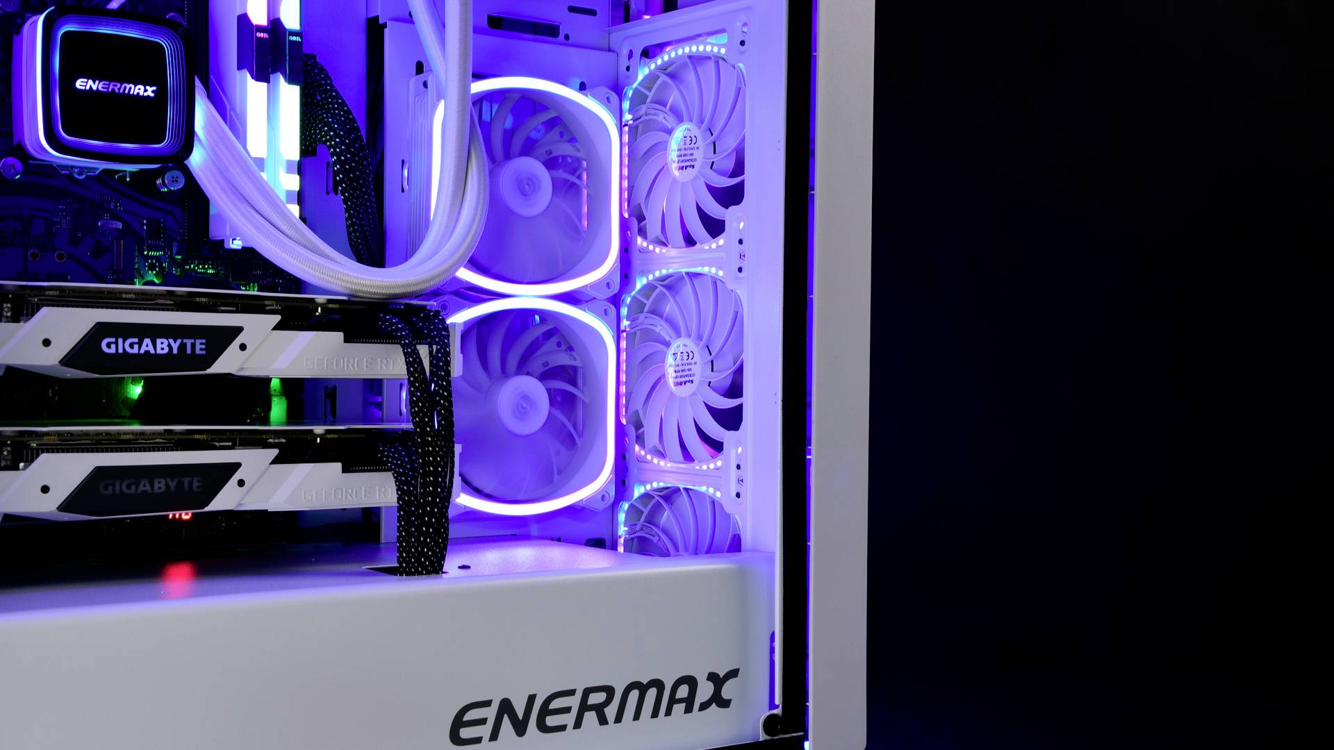 Een computerbehuizing met twee grafische kaarten, verlicht door heldere, gekleurde LED-verlichting. De merknaam 'ENERMAX' is zichtbaar.