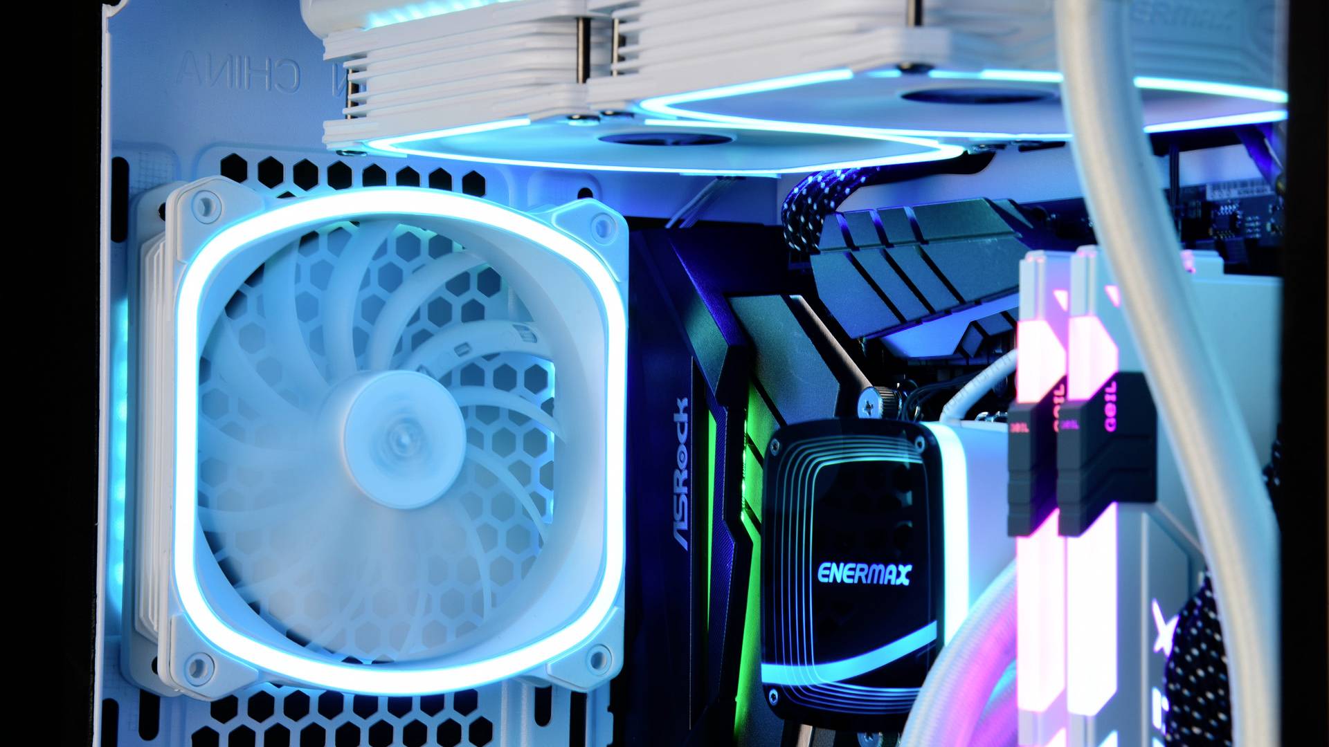 Een computerbehuizing met LED-verlichte ventilatoren en componenten toont moderne gamingapparatuur met een futuristisch ontwerp.