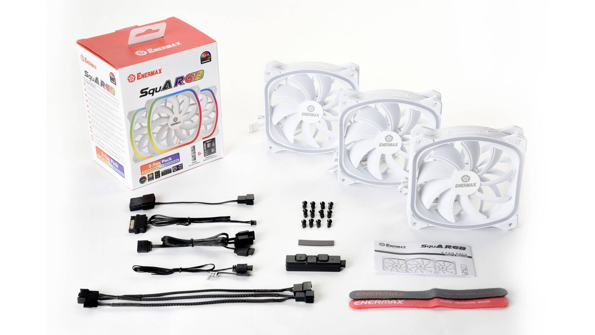 Drie witte pc-ventilatoren met RGB-verlichting naast toebehoren zoals kabels, schroeven en besturings-eenheid. Verpakking toont merklogo en ventilator-design.