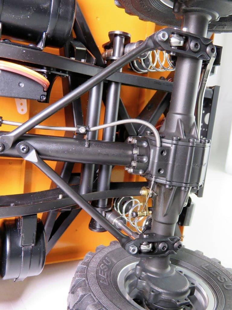 Close-upfoto van een voertuigchassis met schokdempers en vering. Het toont de technische structuur en mechaniek.