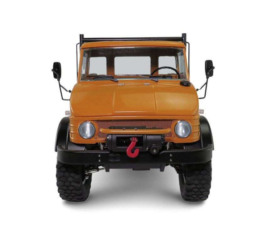 Een oranje terreinwagen, frontaal afgebeeld, met grote banden en een rode haak aan de voorbumper.