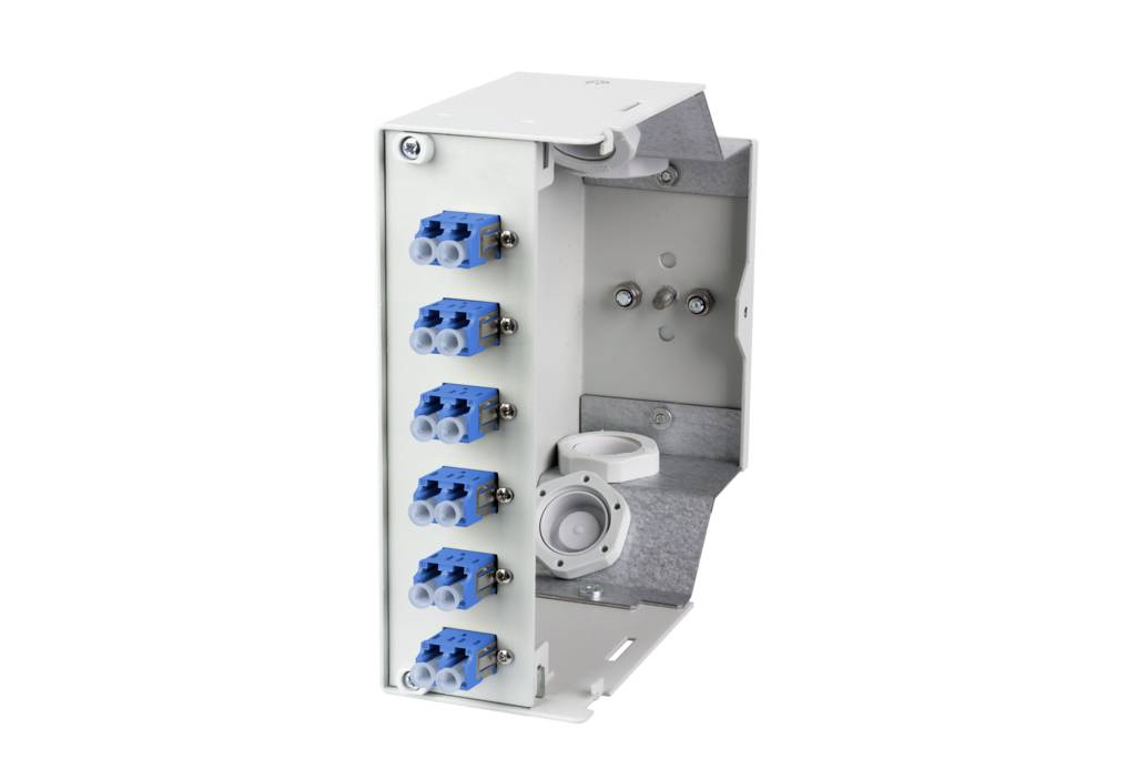 Metalen behuizing met meerdere blauwe en grijze aansluitingen aan de linkerzijde, open aan de rechterkant.