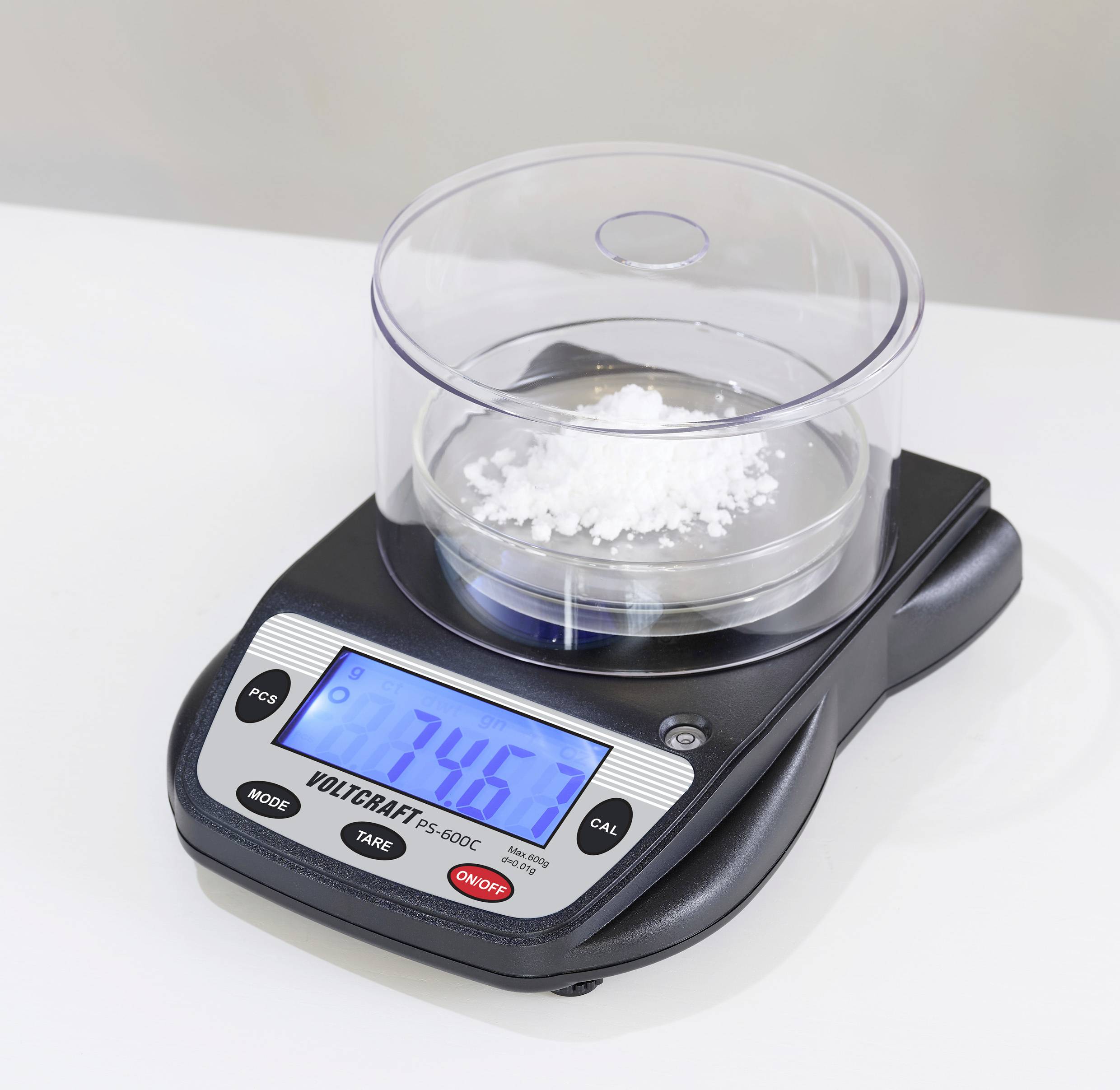 Een digitale weegschaal toont 7,46 gram aan. Een bakje met wit poeder staat erop.