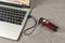 Een rode zaklamp wordt met een USB-kabel aangesloten op een laptop die op een tafel ligt.