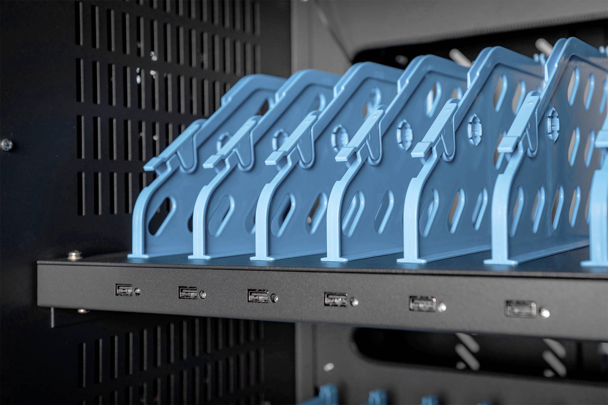 Blauwe metalen bevestigingen in een zwarte behuizing, die waarschijnlijk wordt gebruikt voor computer- of servercomponenten.