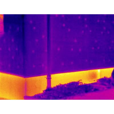 Warmtebeeldopname van een gebouwhoek. De basis toont intensieve warmtestraling in geel; bovenste gedeelten tonen minder warmte in paars.