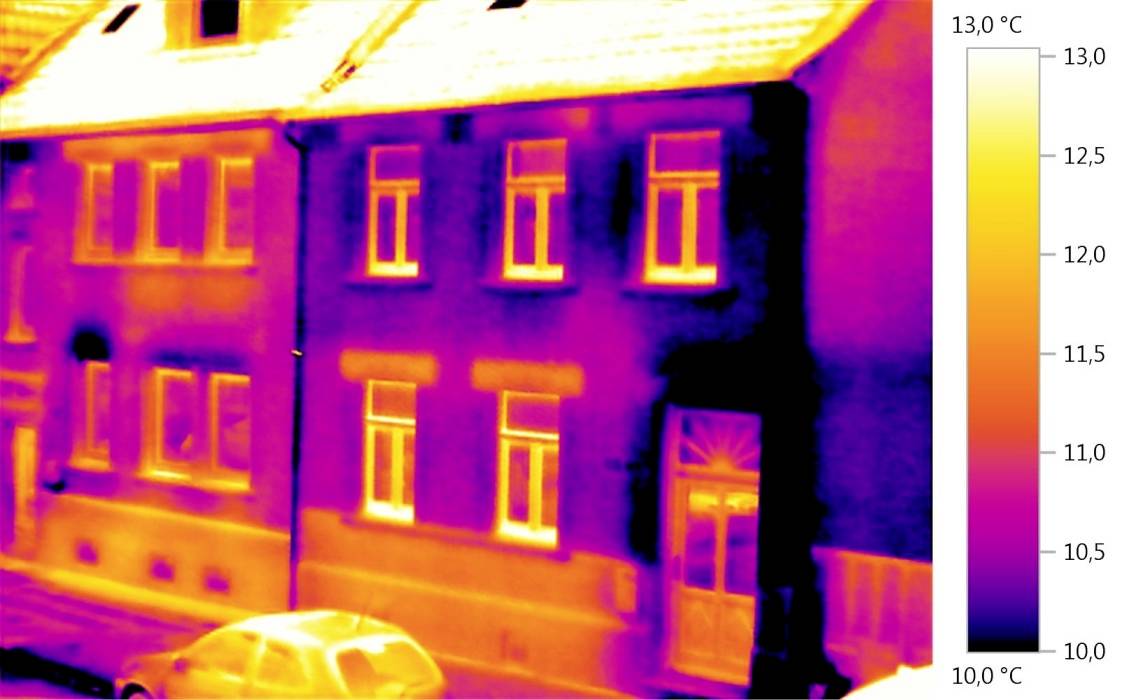 Thermografische afbeelding van een huis toont warmteverlies bij ramen en deuren. Kleurenschaal rechts visualiseert temperatuur van 10 tot 13 °C.