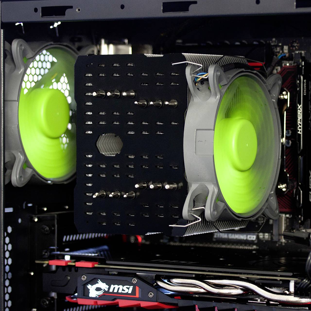 Binnenkant van een computerbehuizing met twee groene ventilatoren voor koeling, een MSI-logo en een zichtbare hardwareinstallatie.