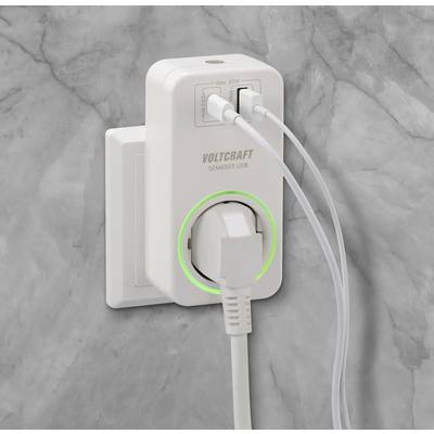 Een wit multi-poort oplaadapparaat steekt in een grijze wandcontactdoos. Twee USB-kabels zijn aangesloten.