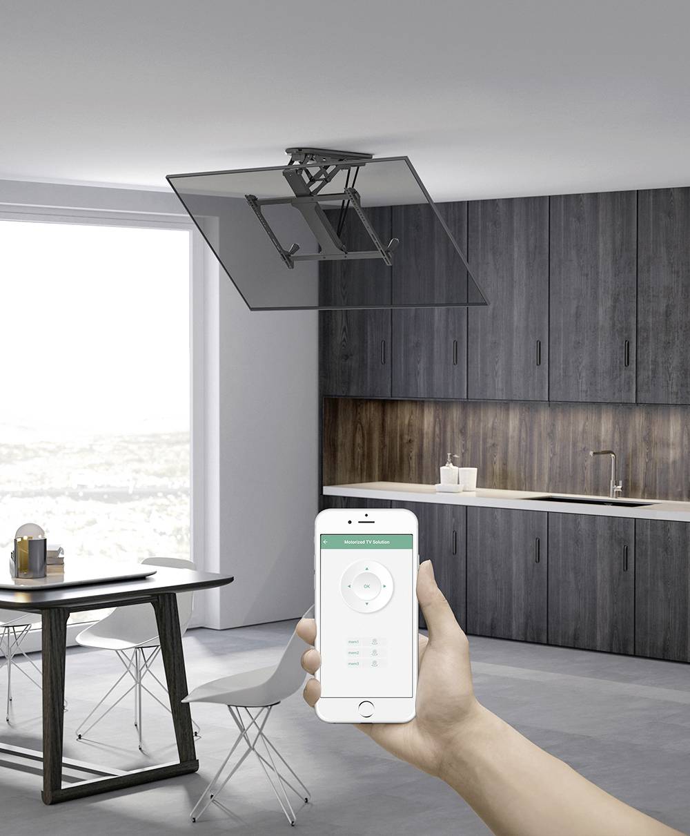 Smartphone bestuurt een plafondafzuigkap in een moderne, minimalistische eetkeuken met grijze kasten en vloer, voor grote ramen.