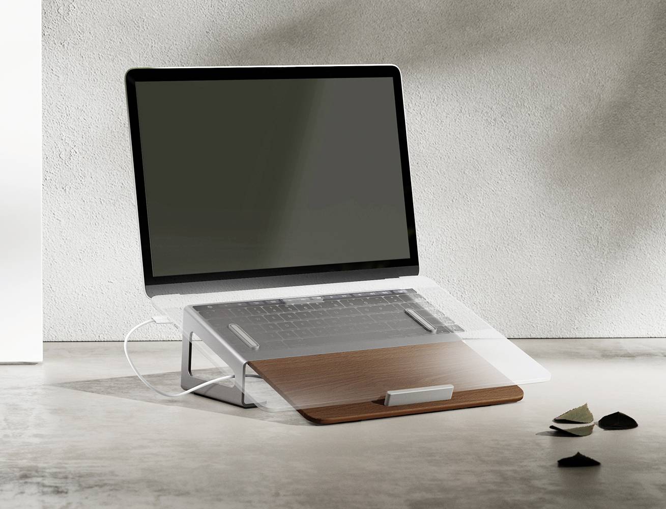 Een laptop staat op een tafel met een ergonomische houder die het scherm kantelt. Op de achtergrond is een grijze muur.