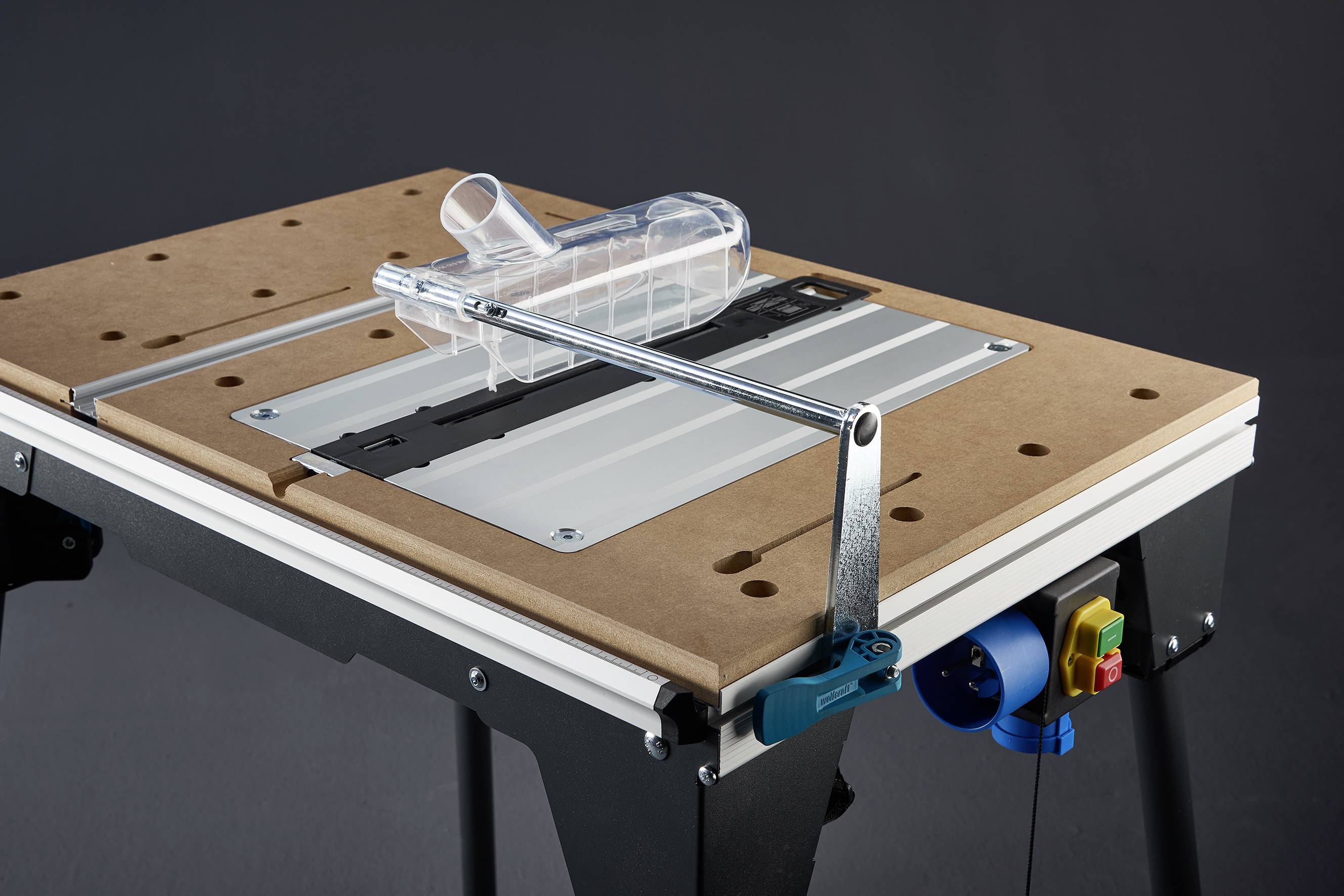 Een tafelcirkelzaag met metalen geleiderail, veiligheidsvoorziening en houten plaat op een zwart frame, klaar voor houtbewerking.