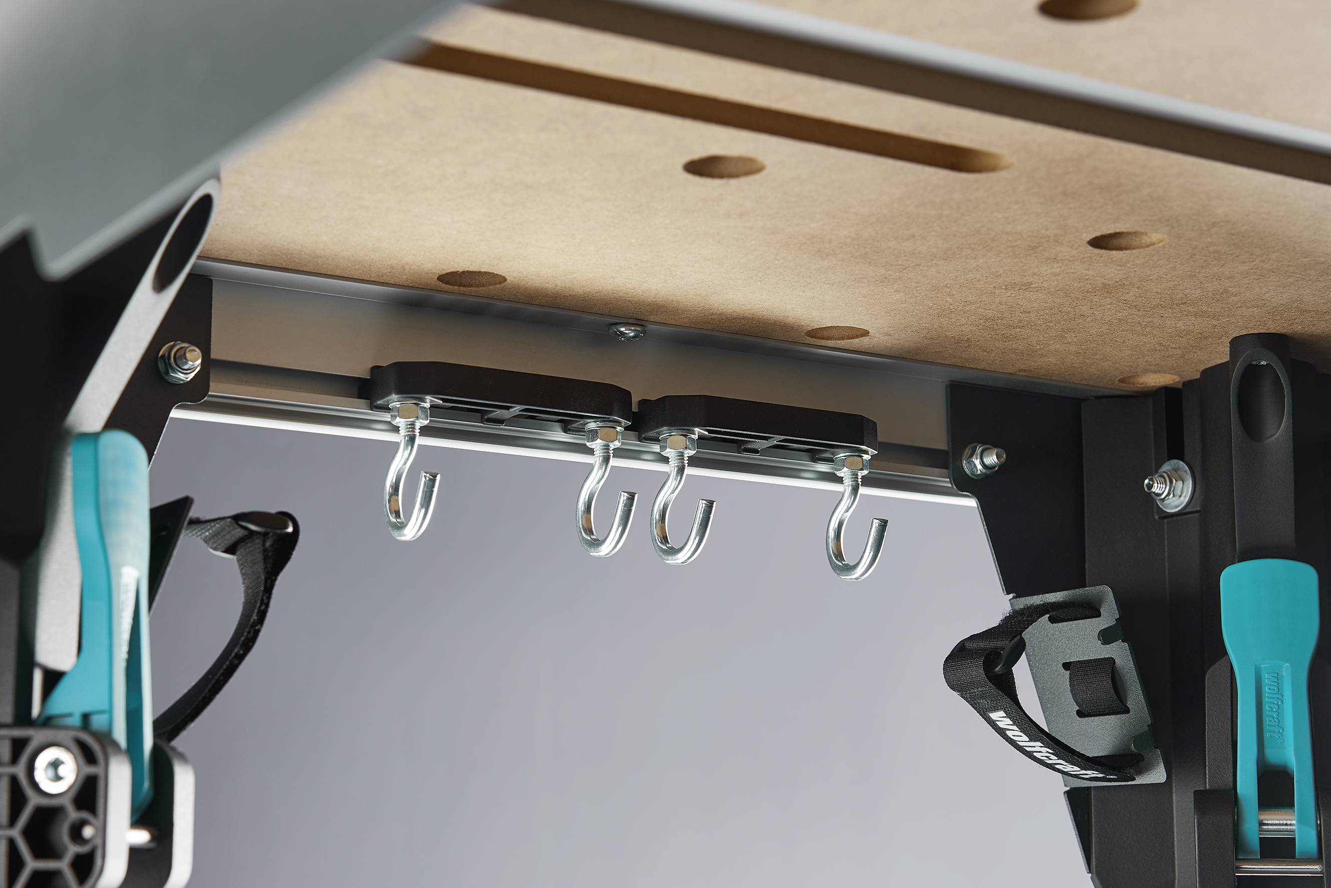 Een werkbank met meerdere haken onder het werkblad om gereedschappen of toebehoren aan op te hangen.