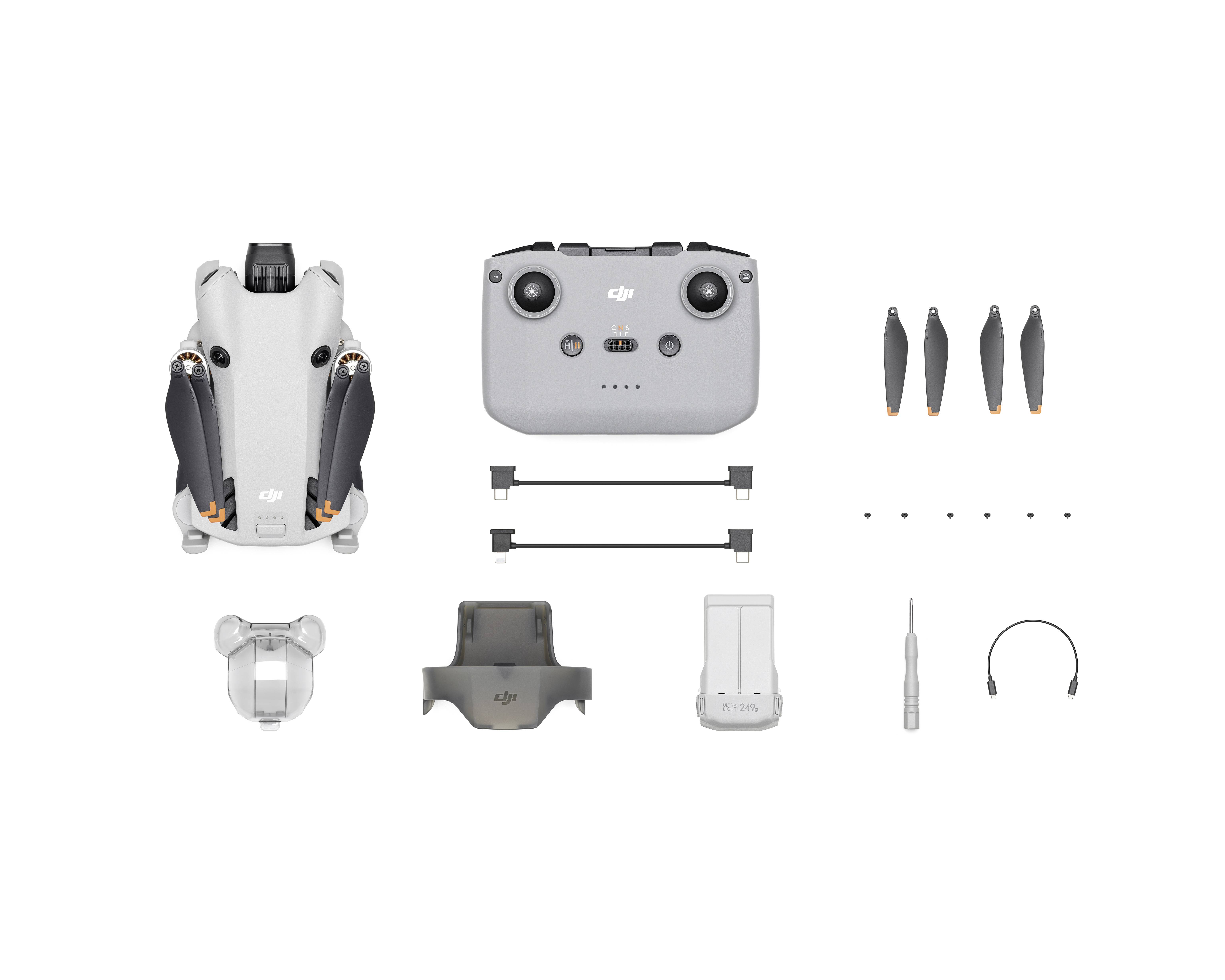 Een compacte drone met afstandsbediening, propellers, reserveonderdelen en toebehoren, inclusief opladers en verbindingskabels, op een witte achtergrond.