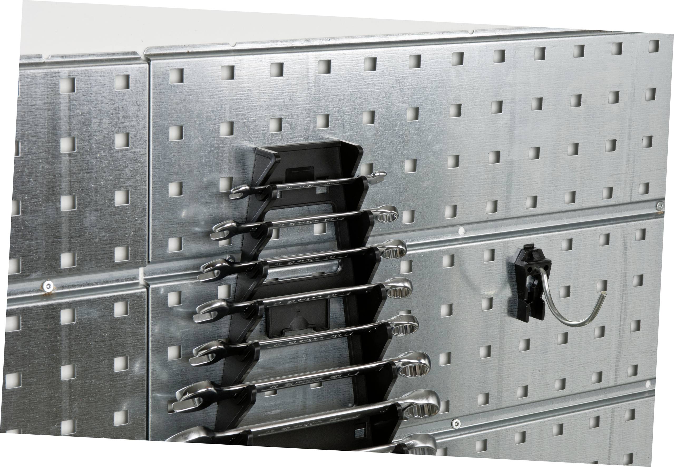Metalen wand met vierkante gaten en gereedschap, waaronder moersleutels, netjes aan haken opgehangen.
