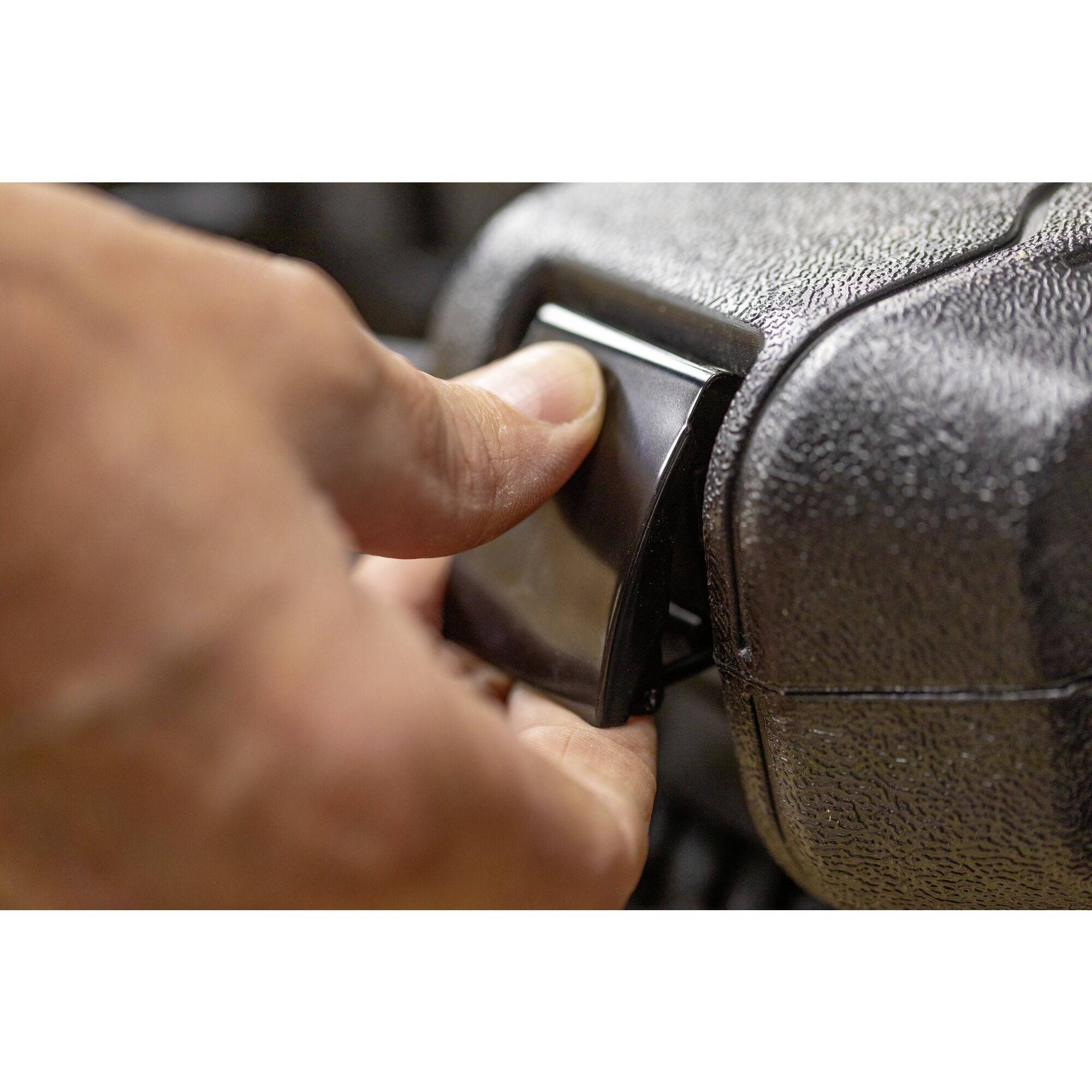 'Een hand trekt aan een hendel om de behuizing van een apparaat te openen, close-up. Kleur: donkergrijs, structuur: ruw.'