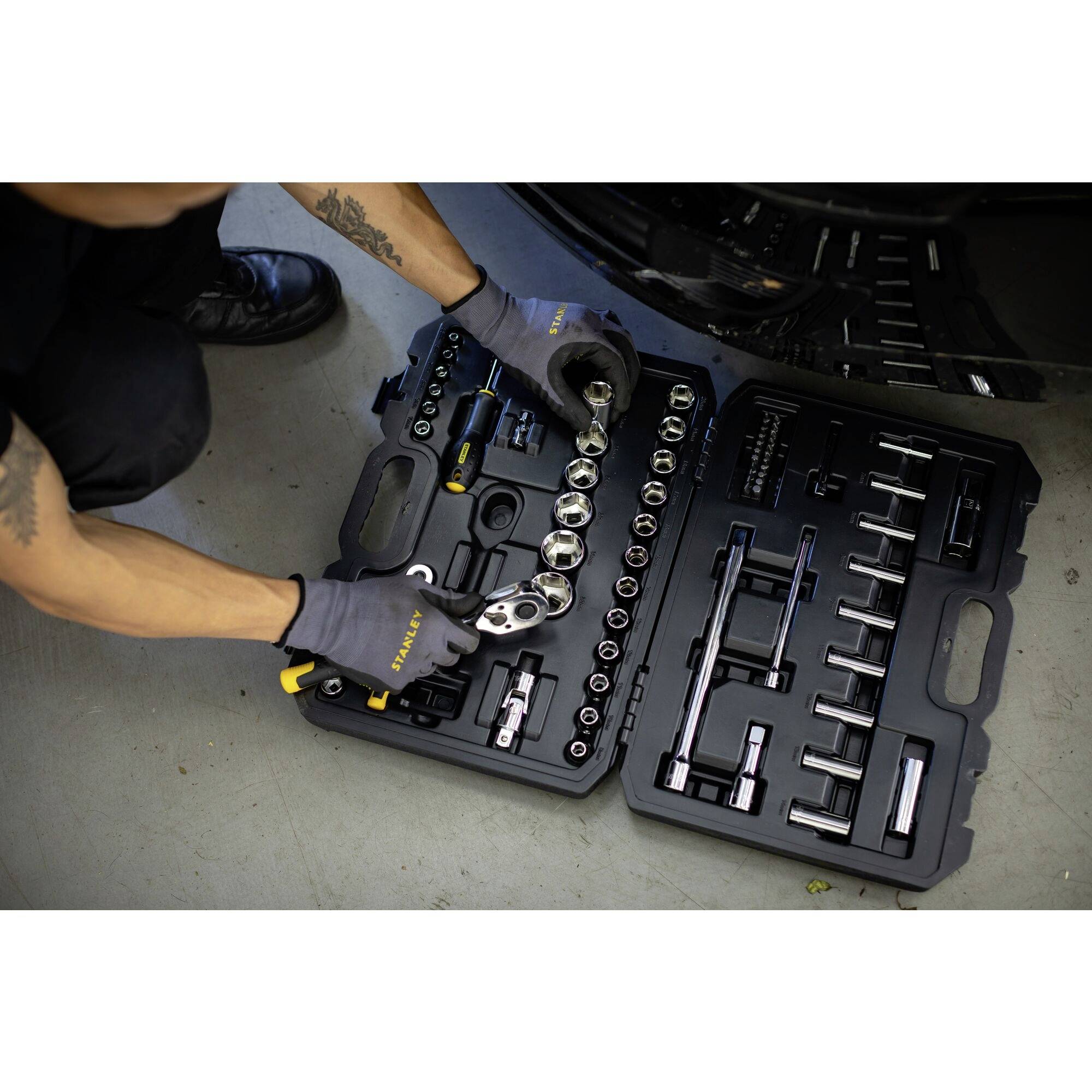 'Man opent een gereedschapskoffer met dopsleutelset, ideaal voor autoreparaties. Gereedschappen netjes gerangschikt in een schuimvoering.'