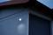 Buitenverlichting is ingeschakeld en verlicht de muur van een gebouw bij het invallen van de schemering, toont modern design en functionaliteit.