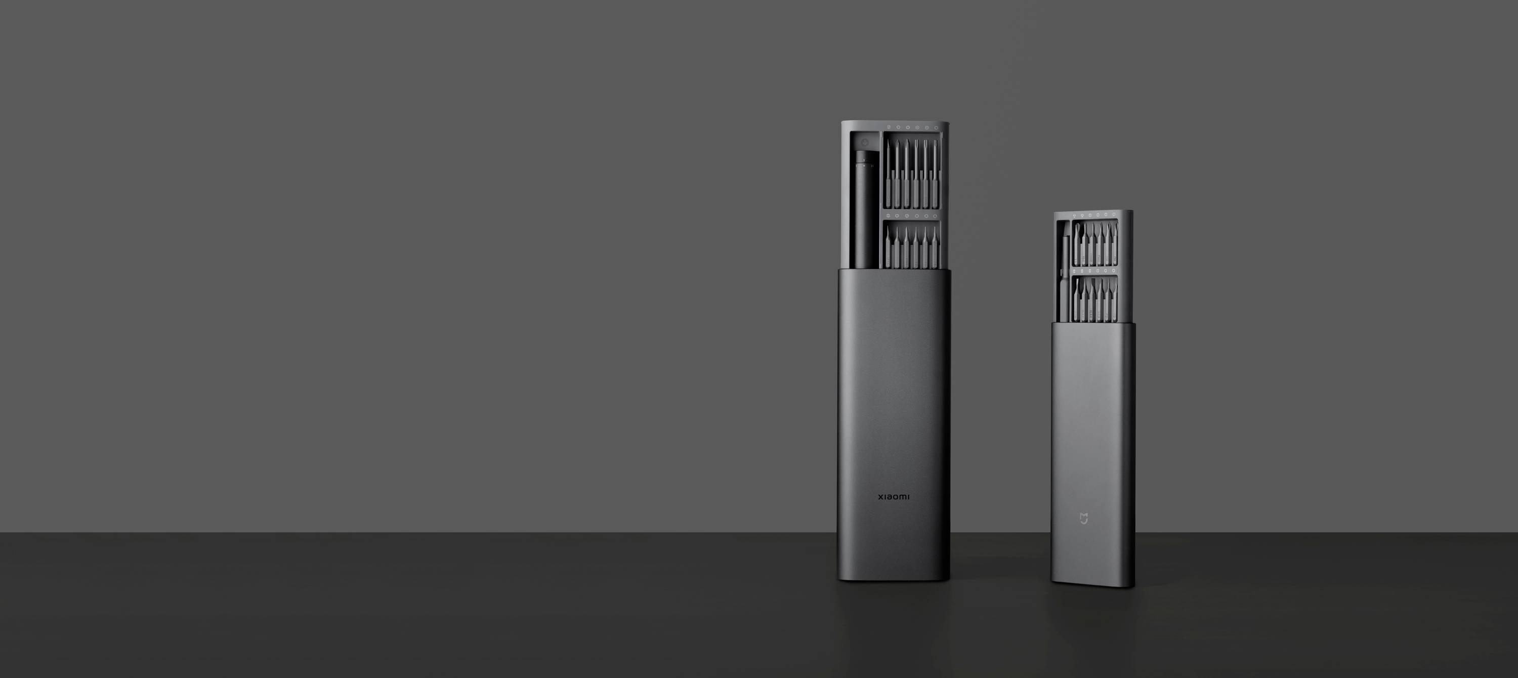 Twee elegante zwarte elektronische apparaten tegen een grijze achtergrond. Ze hebben een modern, minimalistisch design.