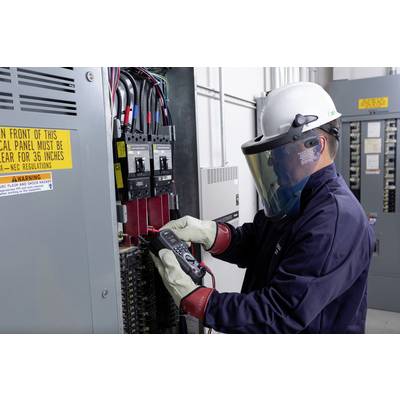 Een technicus in beschermende uitrusting meet met een apparaat in een elektrische schakelkast. Veiligheidswaarschuwingen zijn zichtbaar.