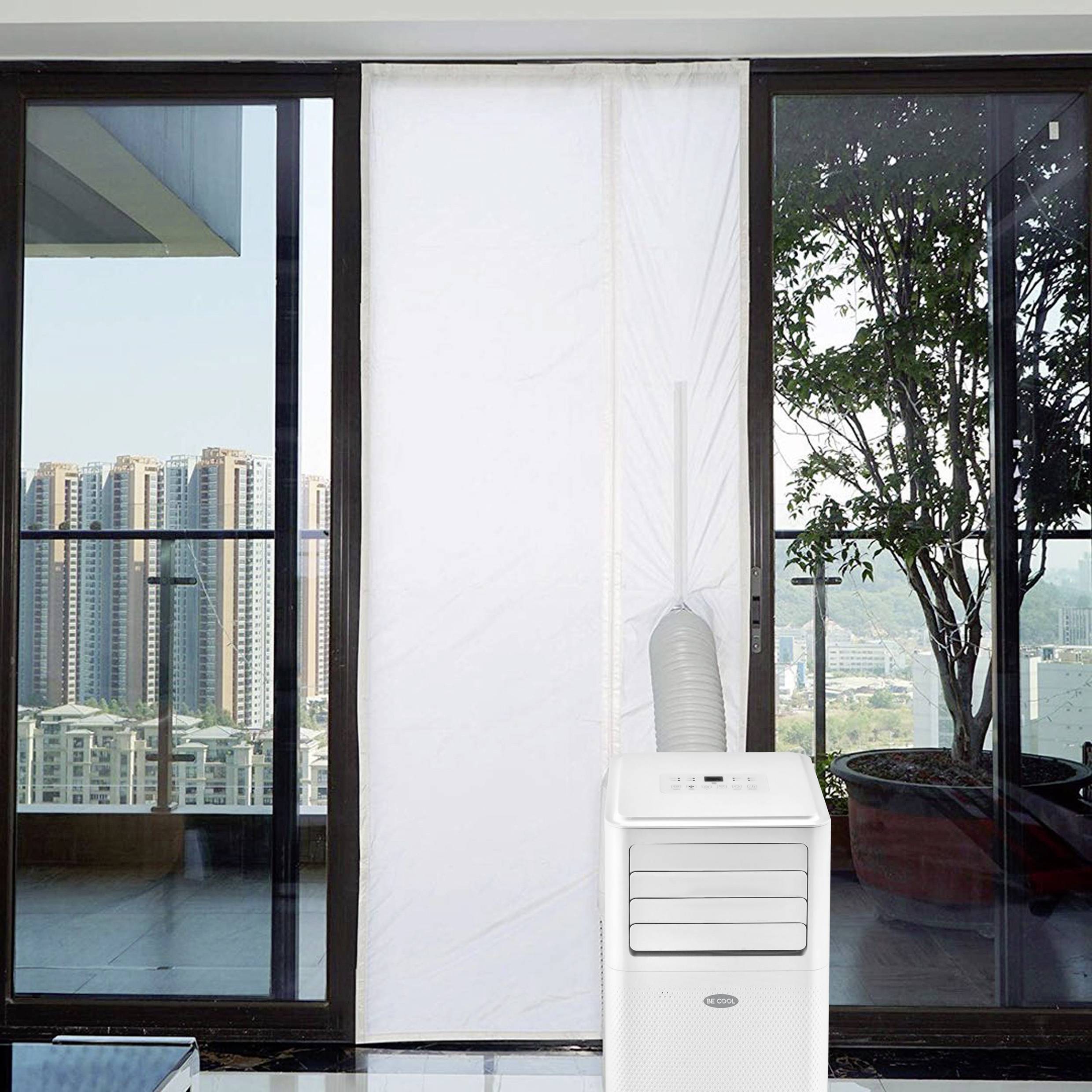 Een mobiele aircooler staat voor een grote raampartij. Buiten zijn wolkenkrabbers en een zonnige hemel te zien.