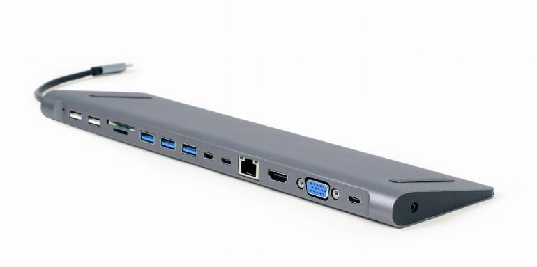 Een grijze USB-C-hub met meerdere poorten, waaronder USB-A, USB-C, HDMI, VGA, Ethernet en een SD-kaartlezer, ligt op een witte achtergrond.
