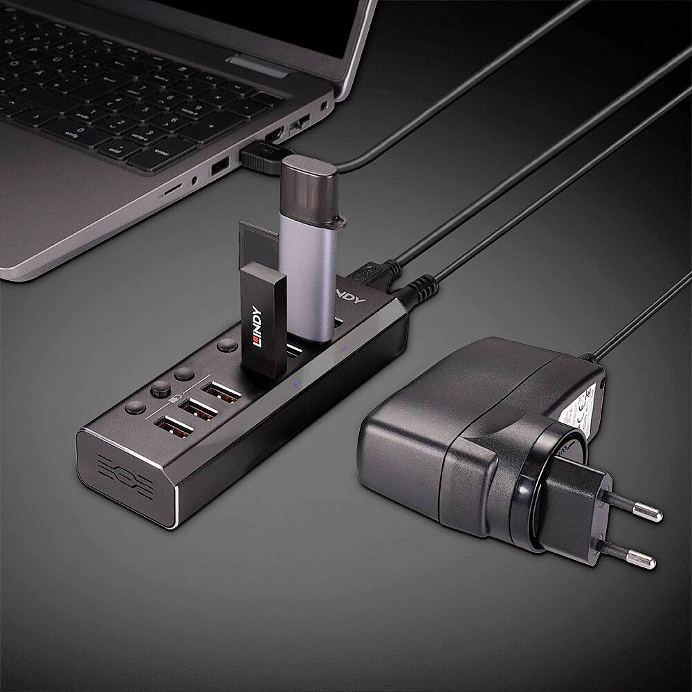 Een laptop is via meerdere kabels en adapters verbonden met een dockingstation. Het dockingstation heeft verschillende USB-poorten.