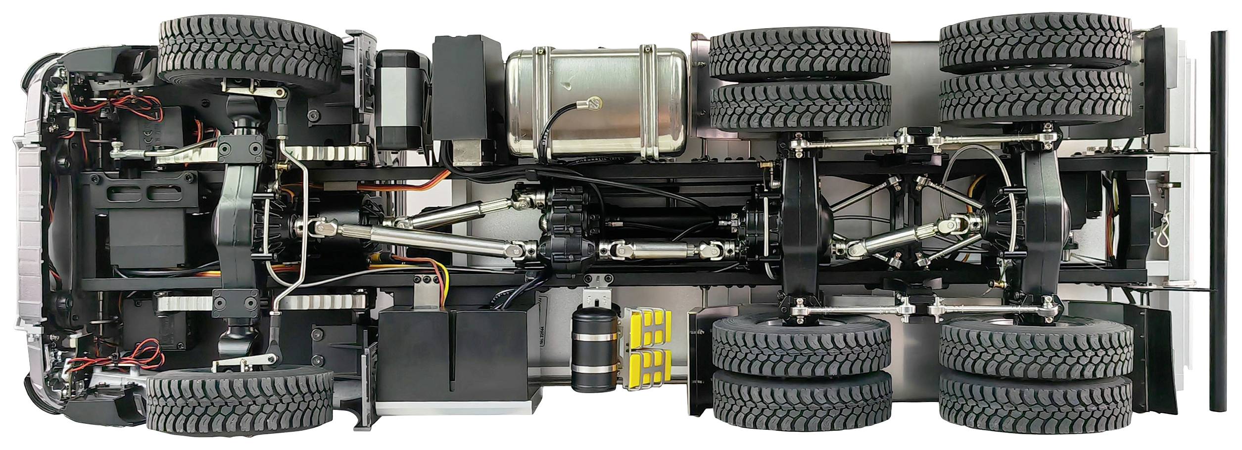 Onderaanzicht van een vrachtwagenchassis met zes grote banden en zichtbare assen, vering en aandrijfelementen.
