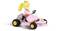 Een figuur met een kroon rijdt in een roze kart.