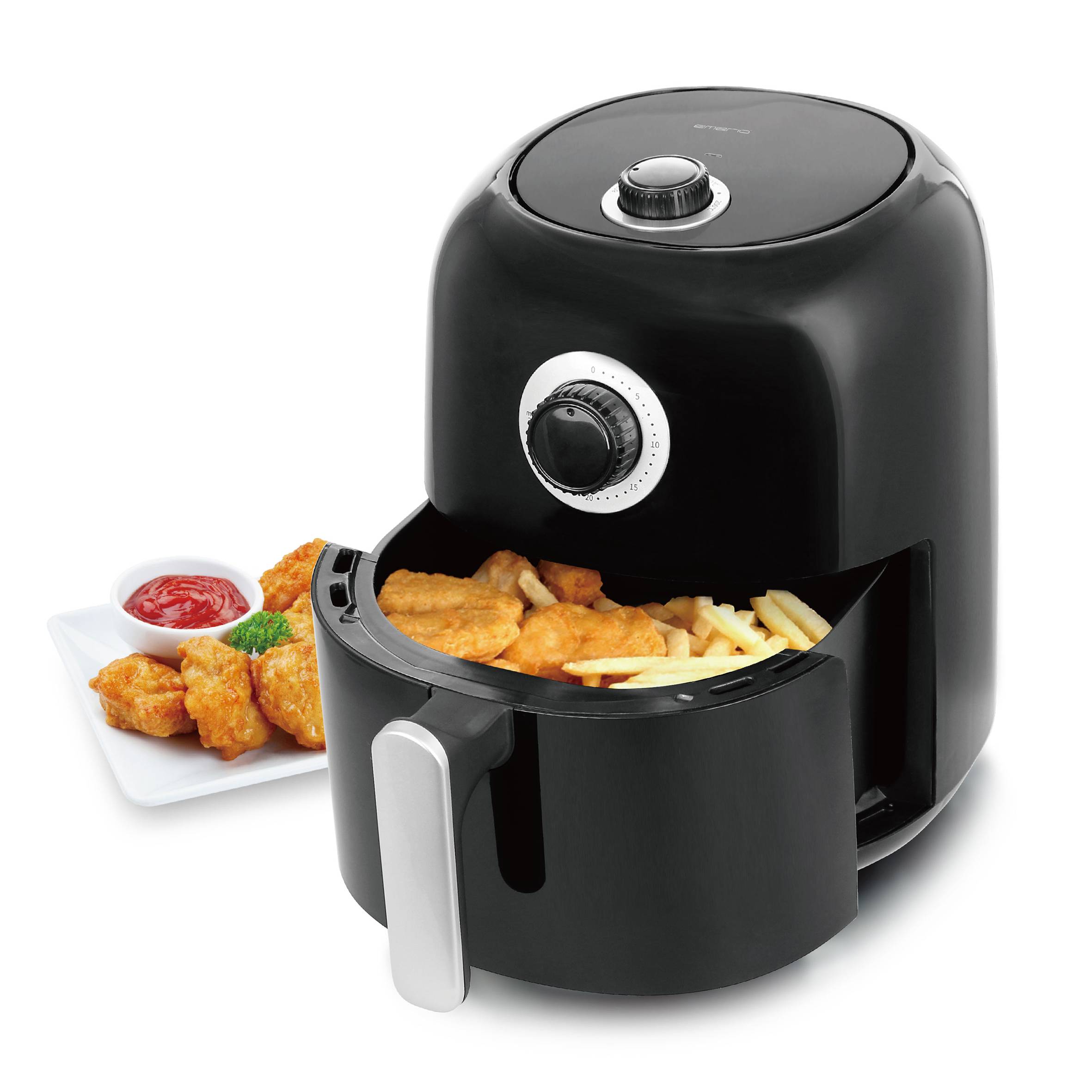 Zwarte heteluchtfriteuse met geopende lade, gevuld met frietjes en nuggets. Naast de friteuse een bord met extra nuggets en saus.