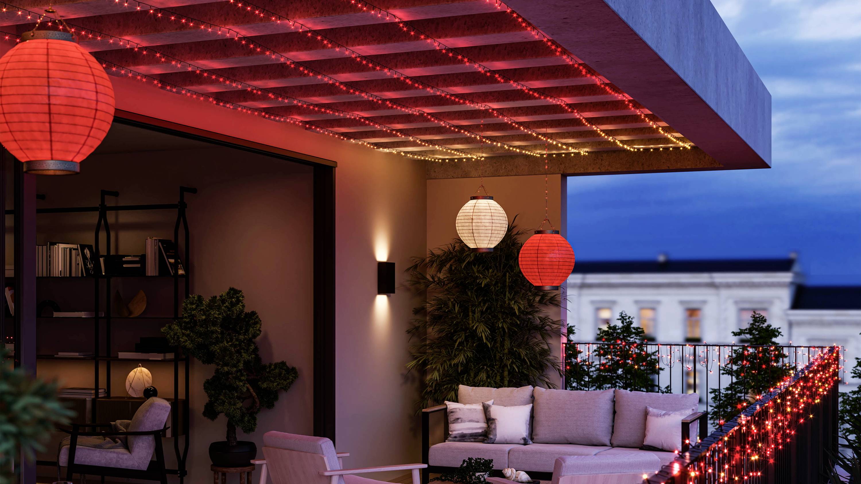 Verlichte terras 's avonds met bank en decoratieve rode lantaarns. Ontspannen sfeer met uitzicht op de hemel.