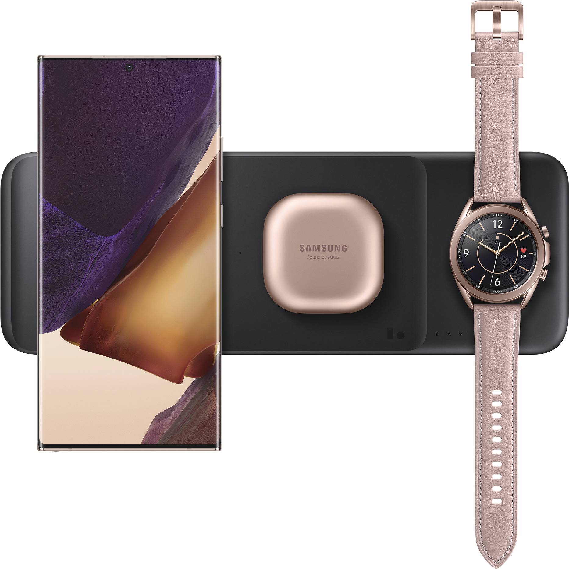 Een smartphone, draadloos laadpad, bronzen oordopjes in een etui en een smartwatch met een roségouden bandje, die allemaal tegelijkertijd worden opgeladen.